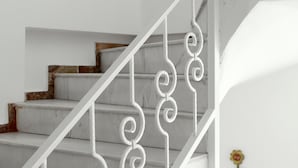 Una escalera con barandillas blancas y escalones de mármol.