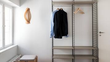 Un dressing avec une étagère métallique, une tringle à vêtements et un radiateur.