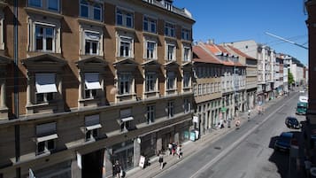 A multi-story building with a row of ground-floor shops and a street in front.