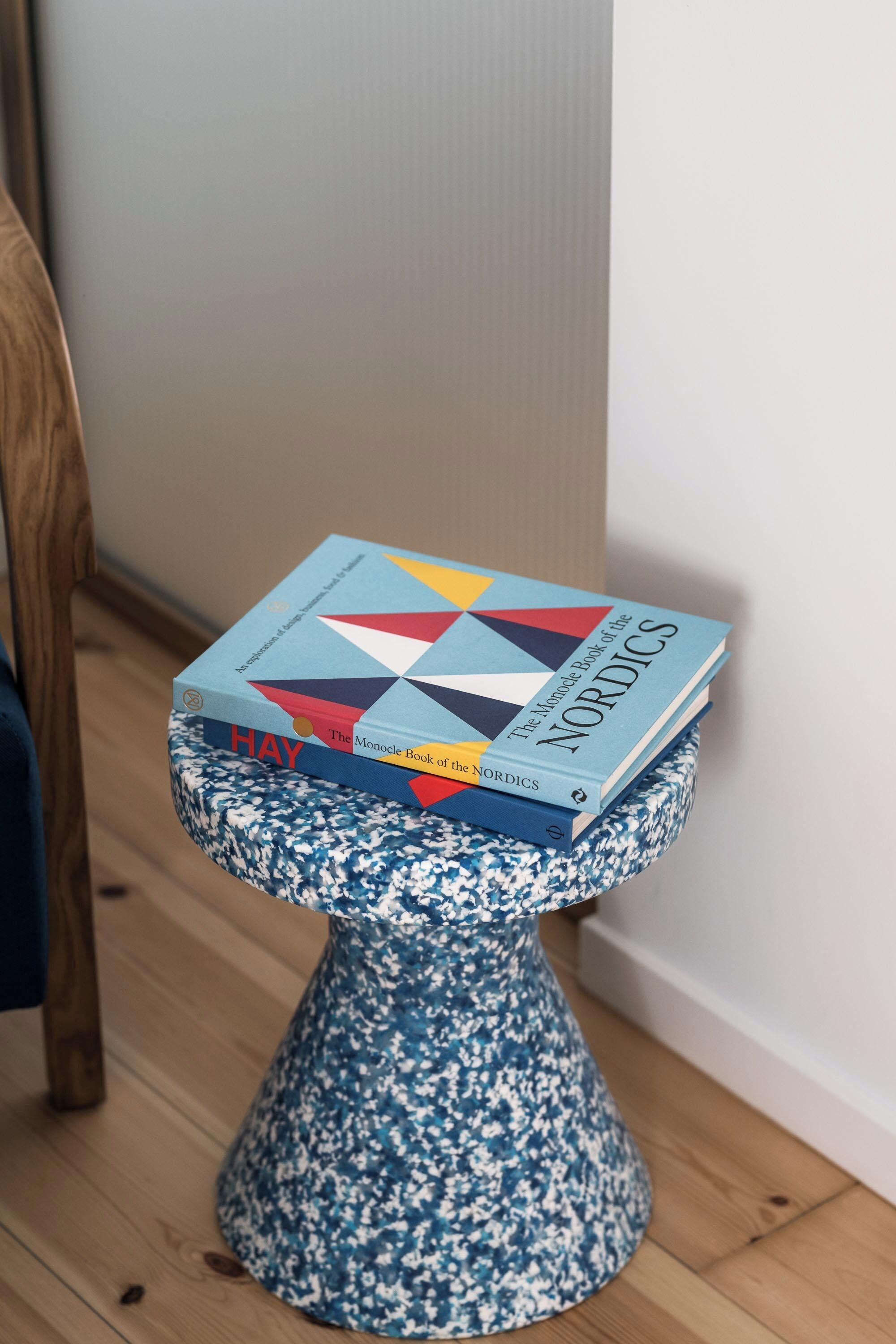 A stack of books on a blue and white patterned stool.