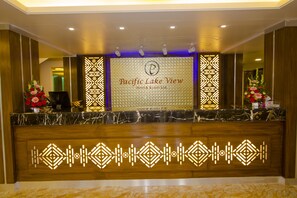 A reception desk at Pacific Lake View Hotel & Resort Ltd. with a marble top and decorative lighting. - Pacific Lake View Hotel (Dhaka)