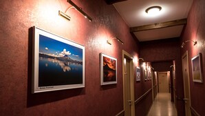 A hallway with framed pictures on the walls, a wooden door, and a light fixture on the ceiling. - Nachalnik Kamchatki (Petropavlovsk-Kamchatskiy)
