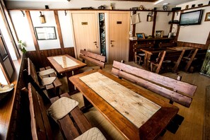 A wooden interior with tables and benches, a television, and a window with a view. - Nachalnik Kamchatki (Petropavlovsk-Kamchatskiy)