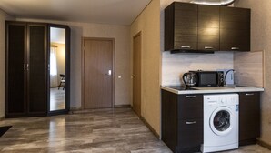 A compact kitchen with a washing machine, a microwave, and a coffee maker. - Nachalnik Kamchatki (Petropavlovsk-Kamchatskiy)