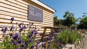 A wooden building with a sign reading "The Slate Yllechan". - The Slate (Bangor)