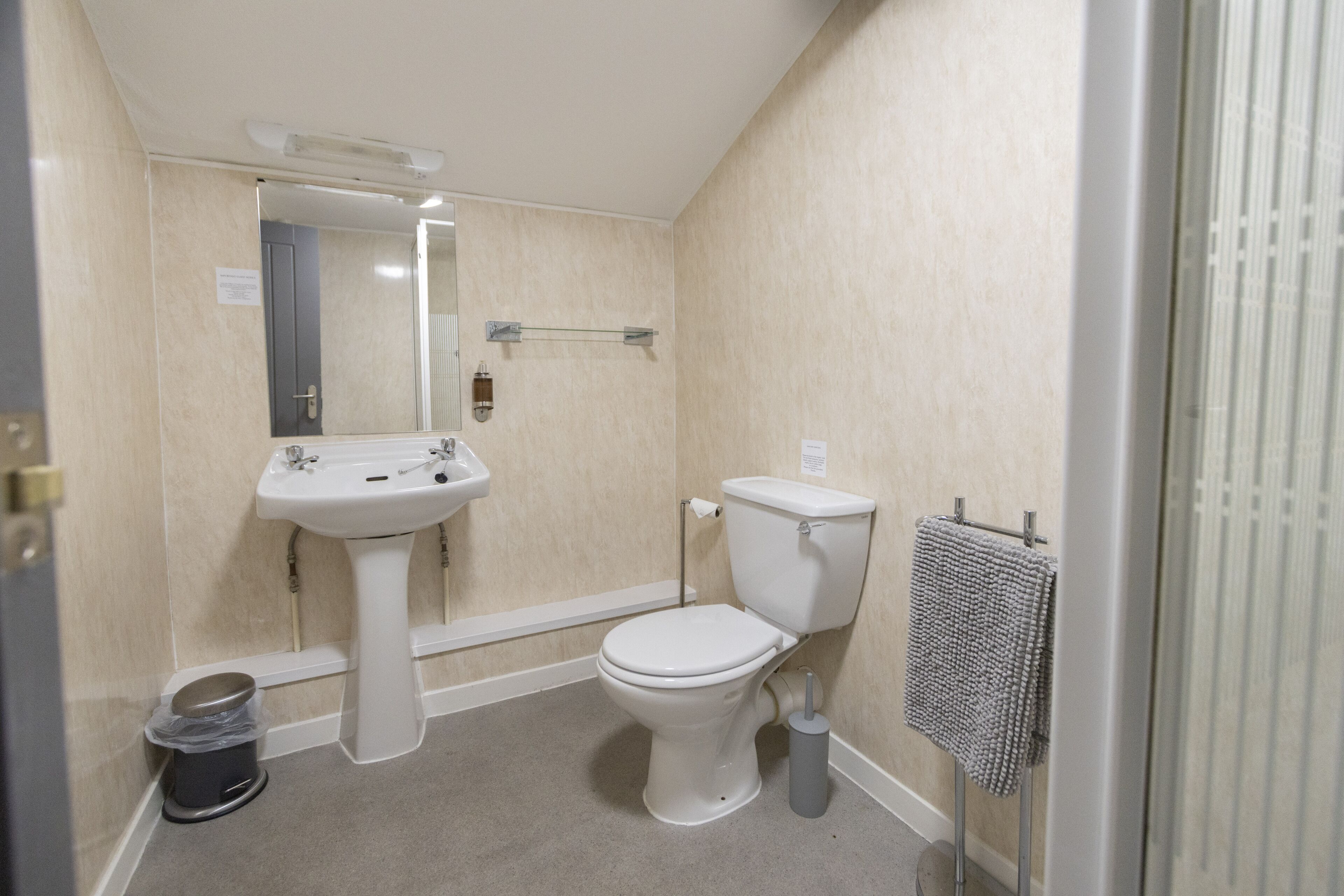 Une petite salle de bain avec des toilettes, un lavabo et un porte-serviettes.
