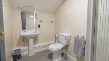 Une petite salle de bain avec des toilettes, un lavabo et un porte-serviettes.