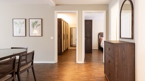 Een modern interieur met een eethoek, houten vloeren en een grote spiegel.