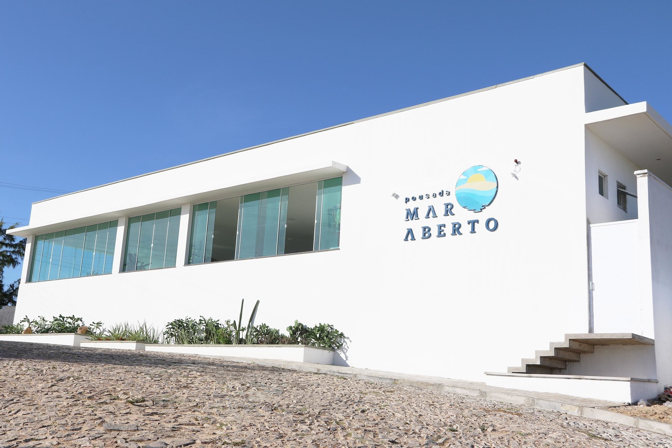 A modern building with large windows and a sign reading "MAR ABERTO".
