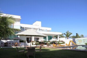 A modern hotel with a pool area, outdoor seating, and a children's play area. - Pousada Mar Aberto (Beberibe)
