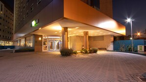 A hotel entrance with a brick facade, a glass entrance, and a well-lit outdoor area. - ibis Styles Curitiba Aeroporto (Sao Jose dos Pinhais)
