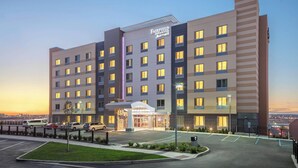 Un hotel Fairfield Inn & Suites Marriott de diseño moderno, con varios pisos y una entrada bien iluminada.