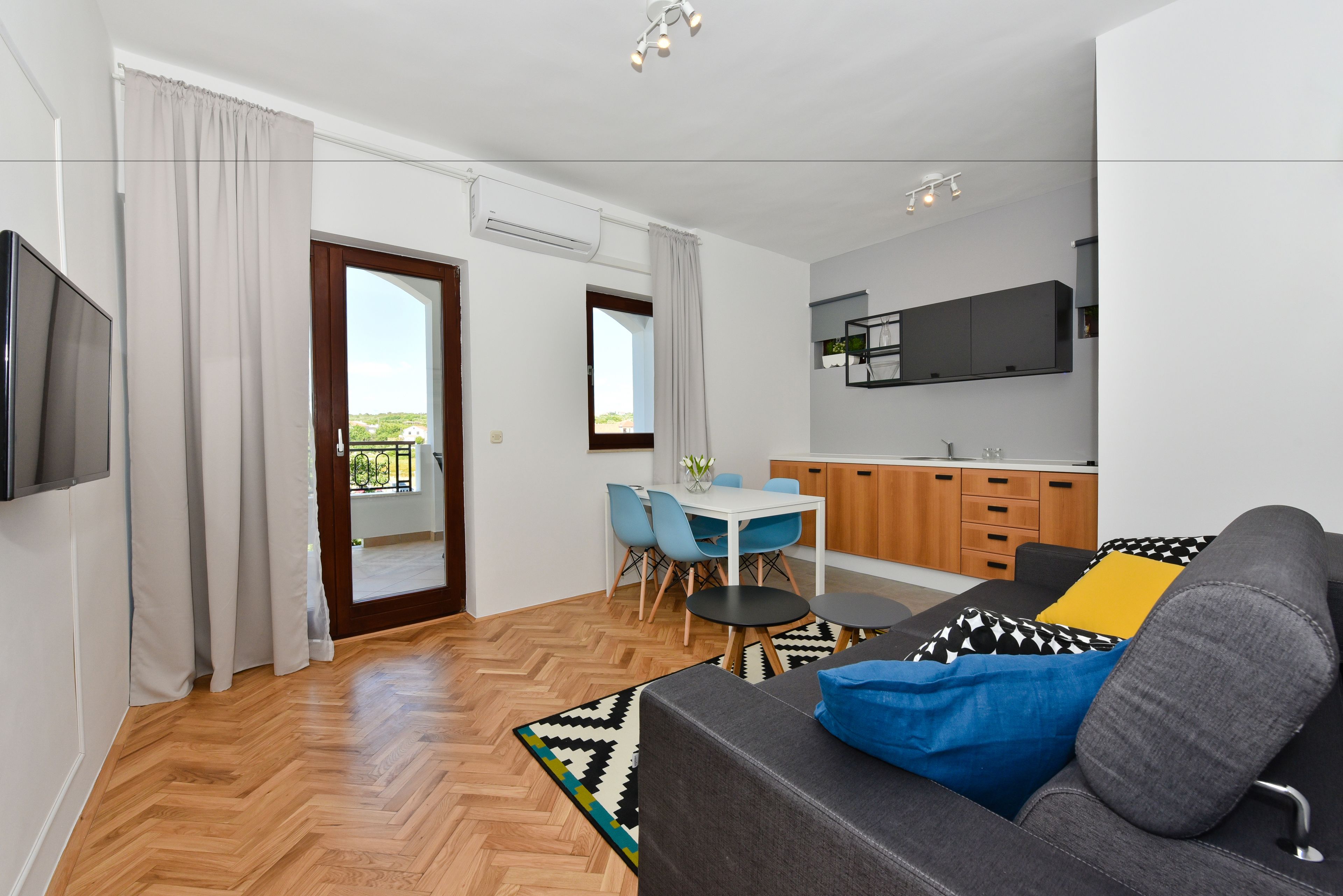 A modern apartment with a living room, dining area, and kitchen.