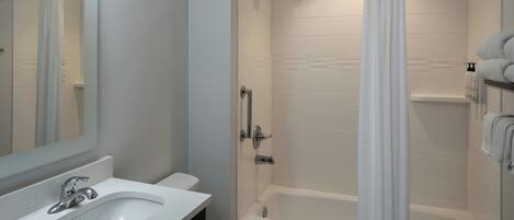 Ein modernes Badezimmer mit Waschbecken, Toilette und Badewanne, alles in Weiß.