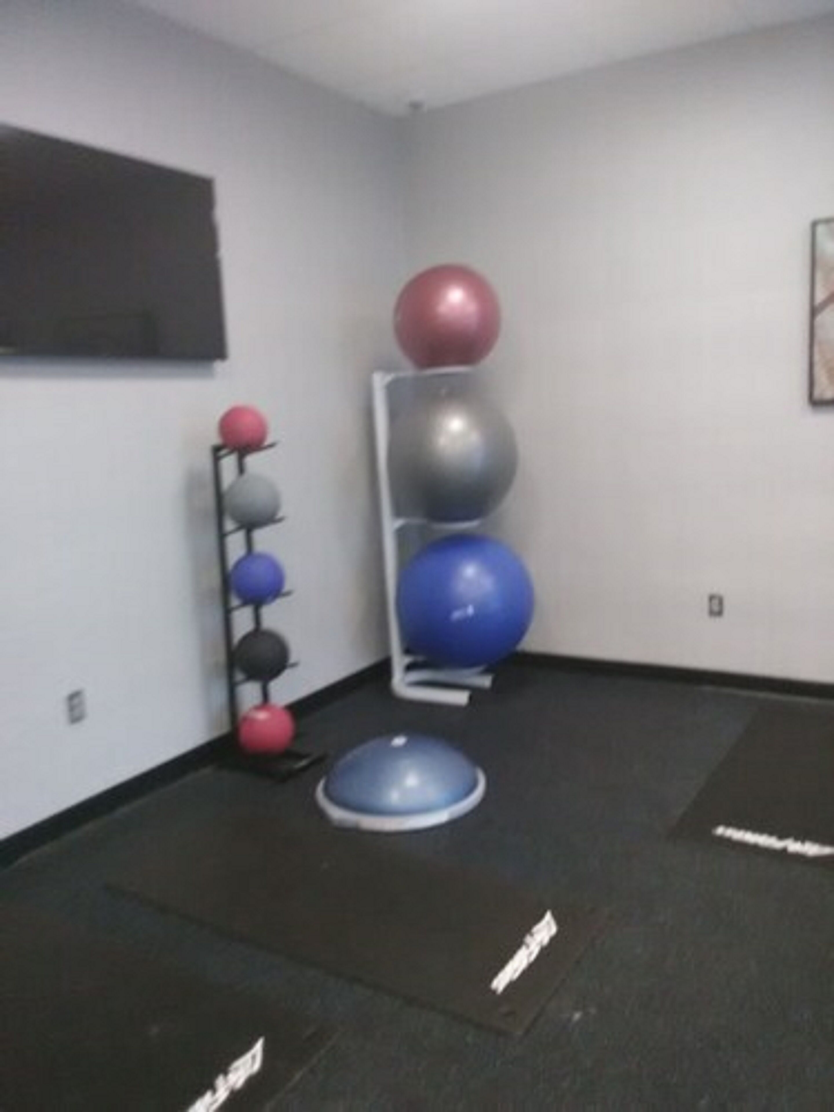 Un gimnasio con pelotas de ejercicio y colchonetas.