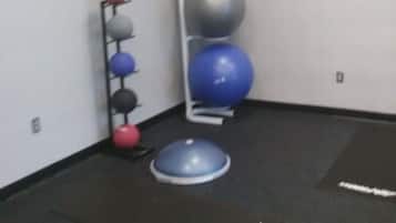Un gimnasio con pelotas de ejercicio y colchonetas.