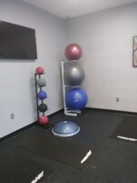 A gym with exercise balls and mats.