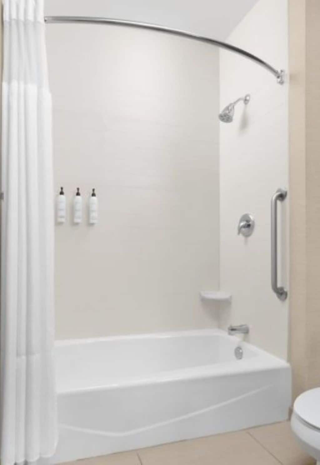 Une salle de bain moderne équipée d’une baignoire, d’une douche et de toilettes.