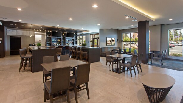 Un restaurante moderno con barra, mesas y sillas para comer.