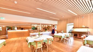Un restaurant doté d’un plancher en bois et de tables dressées pour le service.