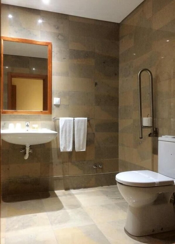 A bathroom with a sink, mirror, two towels, a shower, and a toilet. - Hotel Ponte Sor (Ponte de Sor)