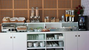 Un buffet proposant une variété de plats, de couverts et une machine à café.