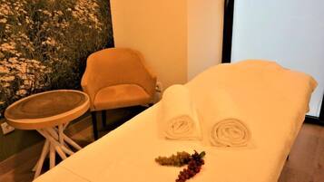 Cozy retreat with a single bed, small table, and chair, featuring a refreshing fruit arrangement.