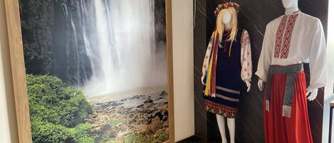 Un mural con una cascada, un maniquí vestido con traje tradicional, y una pared de mármol.