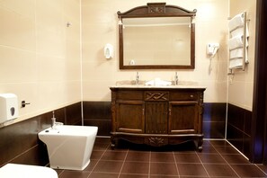 A bathroom with a wooden vanity, a white toilet, and a mirror above the vanity. - Hotel Verhovina (Petropavlivs'ka Borshchahivka)