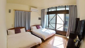 A hotel room with two beds, a TV, and a large window with curtains. - Good Things (Liuqiu)