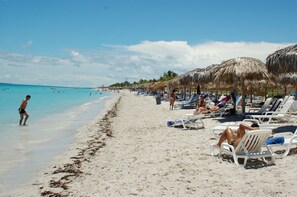 Am Strand, weißer Sandstrand, Liegestühle, Strandtücher