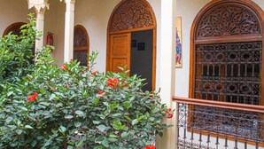 A traditional courtyard with ornate wooden doors and a wrought iron gate. - Riad Dar Tamlil (Marrakech)