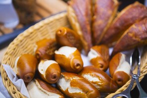 A basket of assorted bread rolls and pastries.