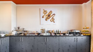A modern kitchen with grey cabinets, a breakfast bar, and a variety of breakfast items. - Hotel Ruf (Pforzheim)
