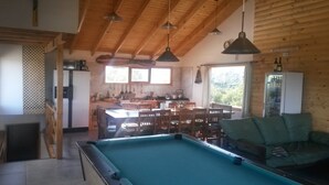 A cozy cabin with a pool, wooden furniture, and a kitchen area. - Hostel Andino (Villa Pehuenia)