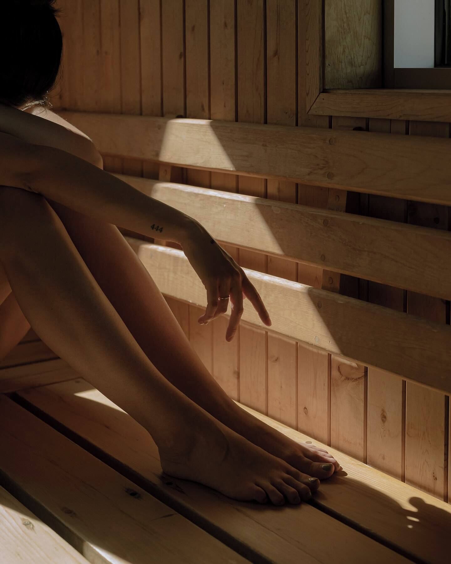 Una persona sentada en unos escalones de madera con una ventana al fondo.