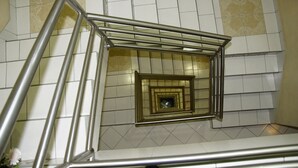 A spiral staircase with metal railings and patterned tiles on the walls. - Hotel Ejecutivo Inn (Ciudad Hidalgo)
