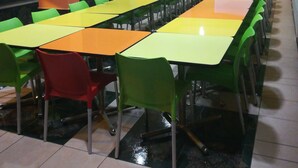 A conference room with multiple tables and chairs, a projector screen, and a water dispenser. - Hotel Ejecutivo Inn (Ciudad Hidalgo)