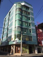 Um hotel de vários andares com design moderno, com grandes janelas e uma entrada destacada.