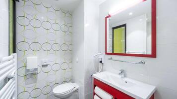 A modern bathroom with a toilet, sink, and mirror.
