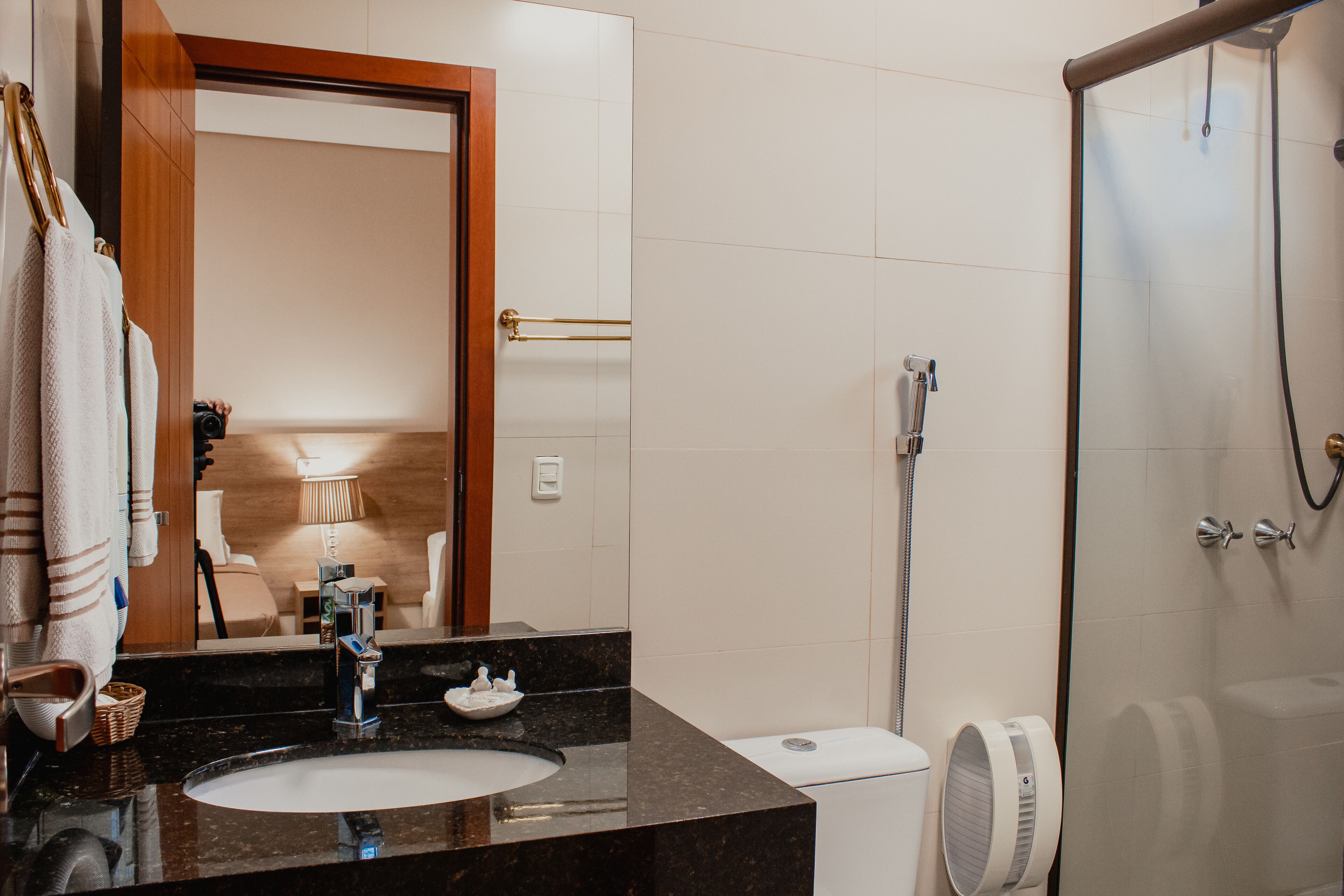 A modern bathroom with a marble sink, a glass shower enclosure, and a visible toilet.