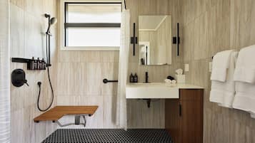 A modern bathroom with a shower, sink, and mirror.