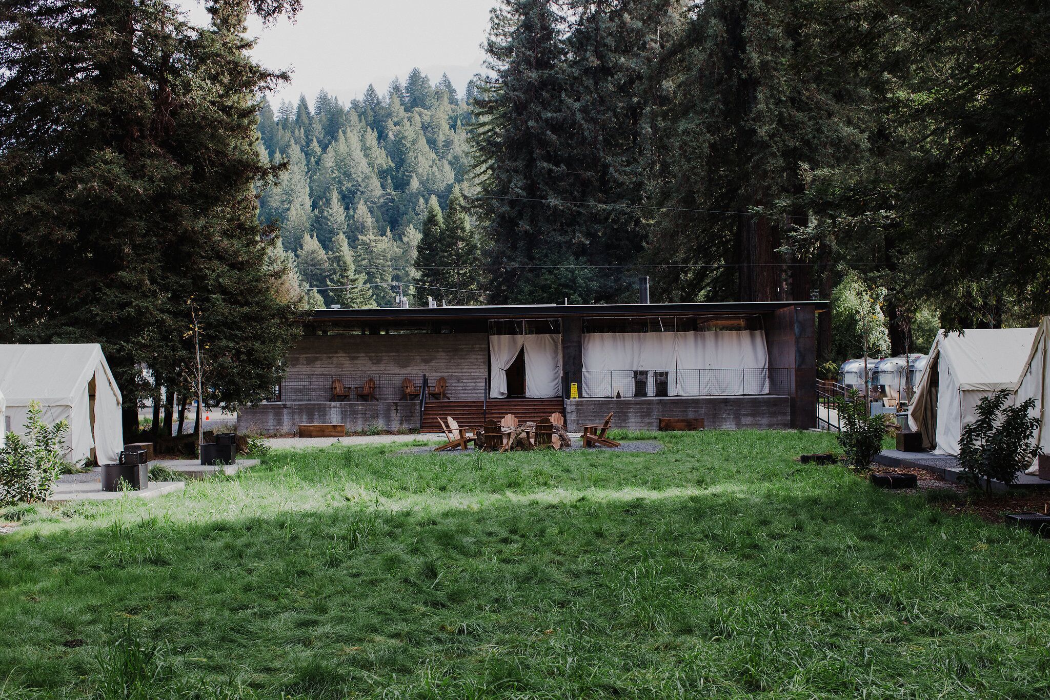 Eine rustikale Holzhütte mit einer Holzterrasse und einem Essbereich.