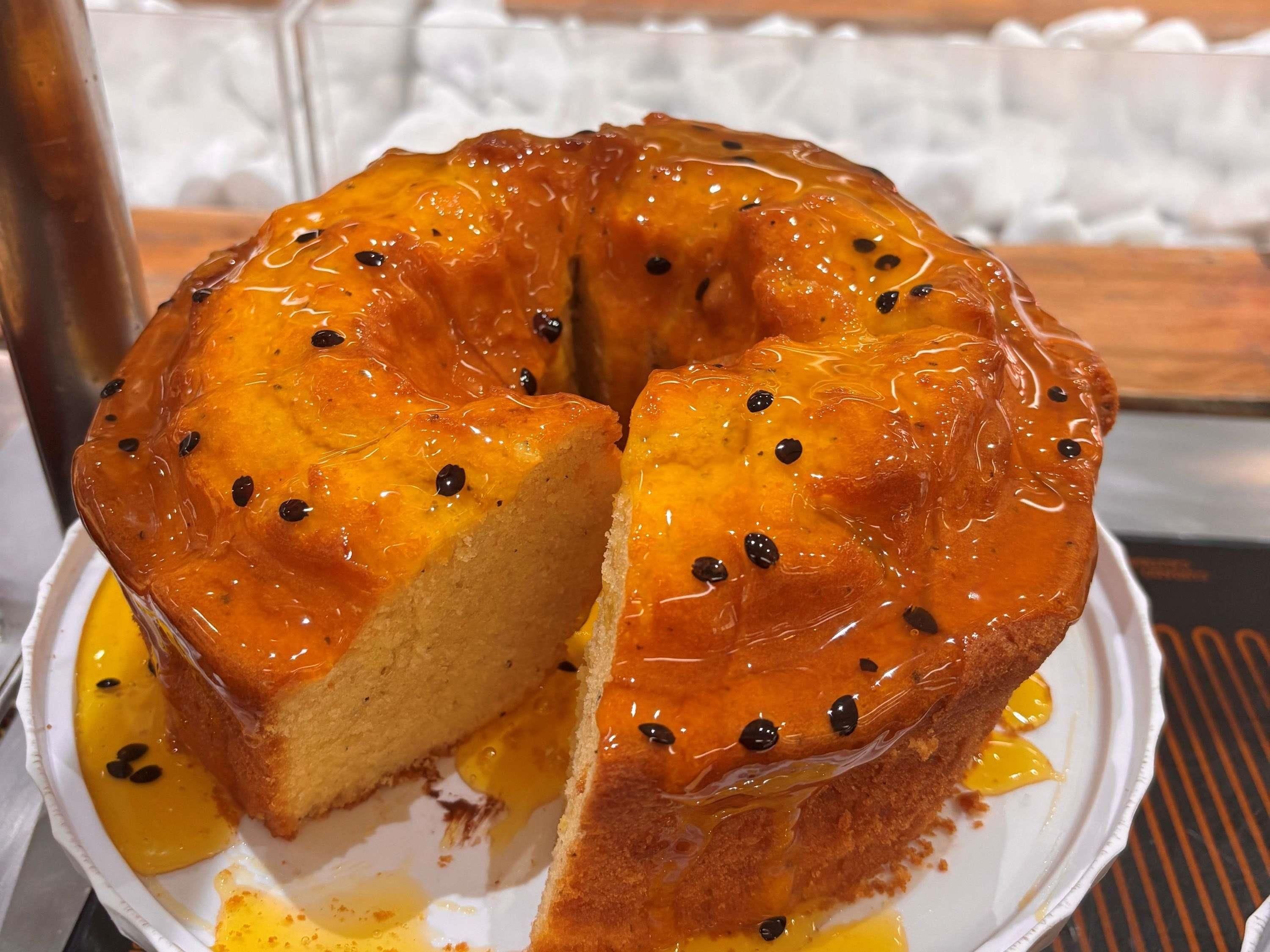 A cake with a glossy glaze and black seeds on top.