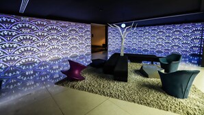 A modern interior with patterned walls, a ceiling light, and contemporary seating.
