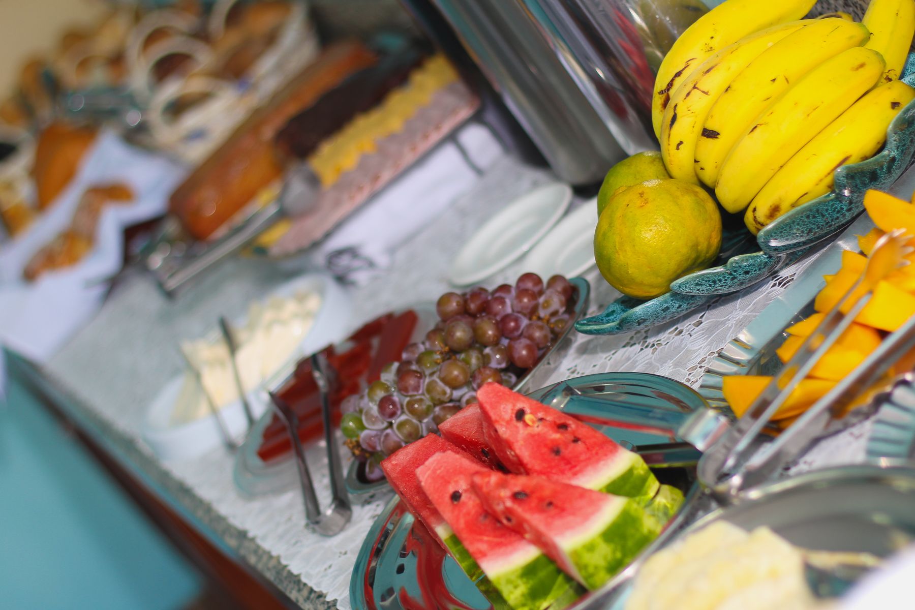 Buffet com diversas frutas e sobremesas.