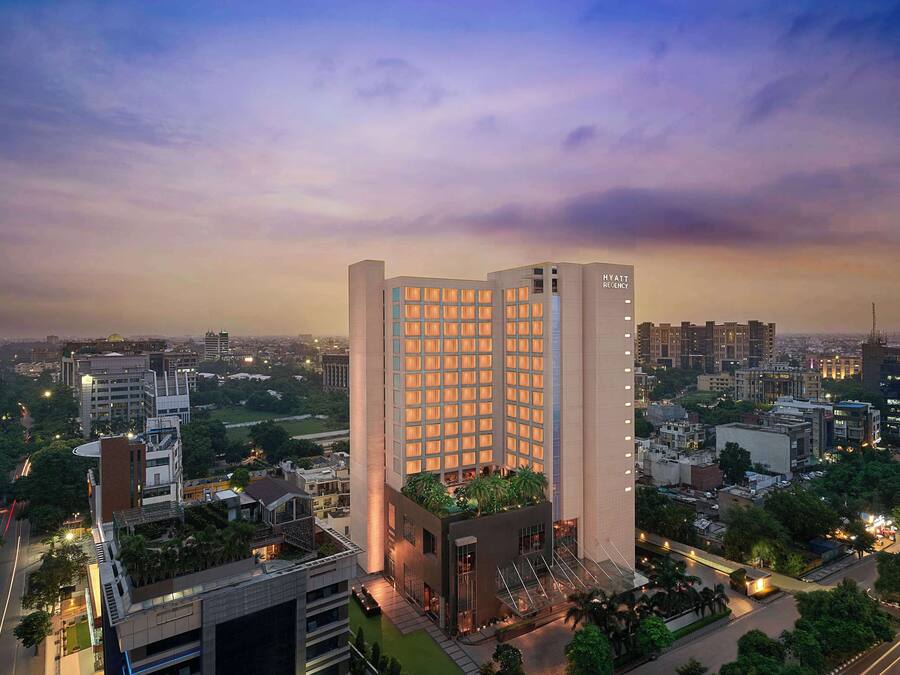 A high-rise hotel with a modern design, featuring a rooftop garden and multiple floors.