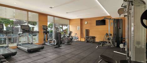 A gym with treadmills, elliptical machines, and weightlifting equipment.