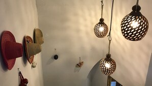 Una escalera con barandilla, un perchero en la pared y lámparas esféricas colgantes.