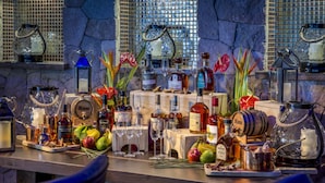 Un espace bar avec diverses bouteilles de spiritueux, des verres et des objets de décoration.